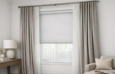A modern living room window with layered shades and drapes, illustrating contemporary window treatment styling for privacy and light control.