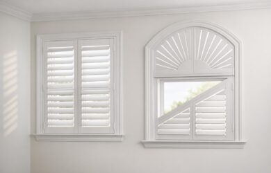 A stock photo showing classic plantation shutters on a rectangular window and specialty shutters on an arched window, highlighting custom shutter styles in a bright, modern interior.